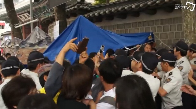 2012년 5월, 대한문 앞의 쌍용차 농성장을 경찰이 무력으로 철거하고 있다. 이 과정에서 격한 몸싸움이 벌어졌고 김정우 당시 쌍용차 지부장이 연행되기도 했다.(사진출처-칼라TV 영상 캡쳐)