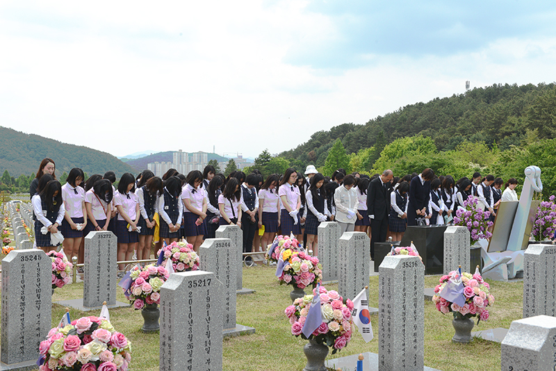 김오복 교장이 광주대성여중(당시 교감) 학생들과 함께 대전현충원을 참배하고 있다. 참배 후에는 현충원 묘비를 닦으며 나라사랑정신을 되새겼다. (사진=나라사랑신문)