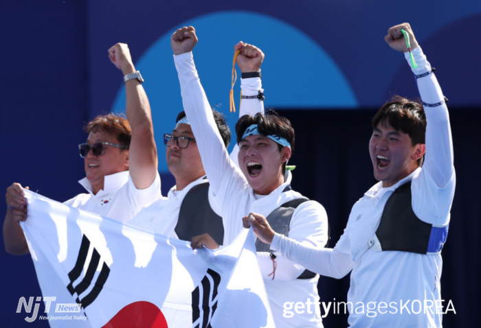 파리, 프랑스 - 2024년 7월 29일: 2024 파리 올림픽 3일째, 앵발리드 에스플러네이드에서 열린 남자 양궁 단체전 결승에서 대한민국 팀의 김제덕, 김우진, 이우석 선수가 프랑스 팀을 상대로 금메달을 획득한 후 기뻐하고 있다. (사진: Julian Finney/Getty Images 제공)